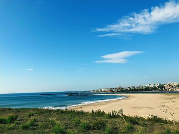 Scenic view of beach against blue sky