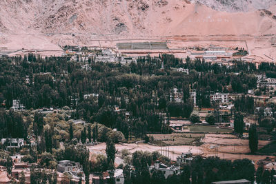 High angle view of trees and buildings on field