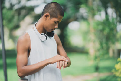 Young man looking away while standing outdoors