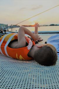 Boy in boat against sky