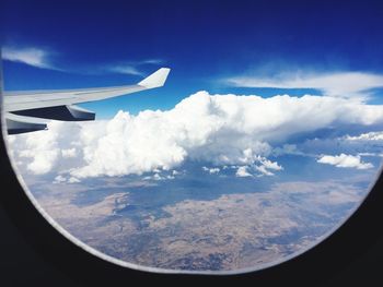 Aerial view of clouds over landscape seen from airplane