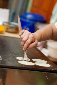 Cropped hand of person preparing food on table