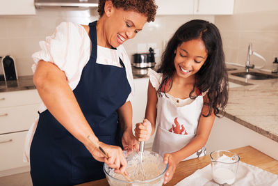 Portrait of young woman preparing food at home