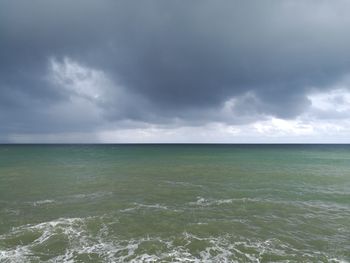 Scenic view of sea against storm clouds