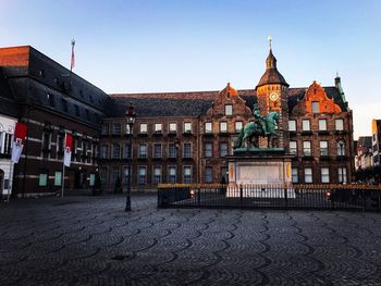 Statue in city against clear sky