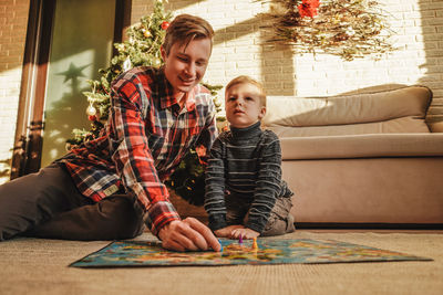 Portrait of smiling woman sitting on table at home