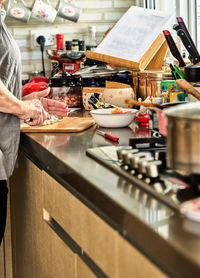 Chef cuts cheese in the home kitchen, for cooking according to a recipe from the internet