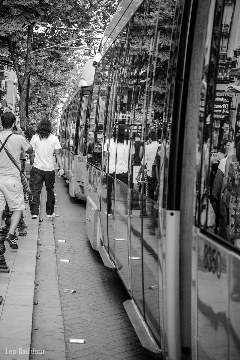 building exterior, architecture, built structure, city, men, walking, street, city life, lifestyles, person, transportation, incidental people, leisure activity, mode of transport, tree, day, car, building, city street