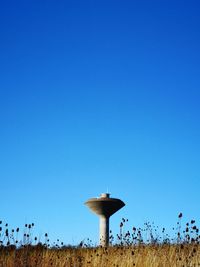 Built structure on field against clear blue sky