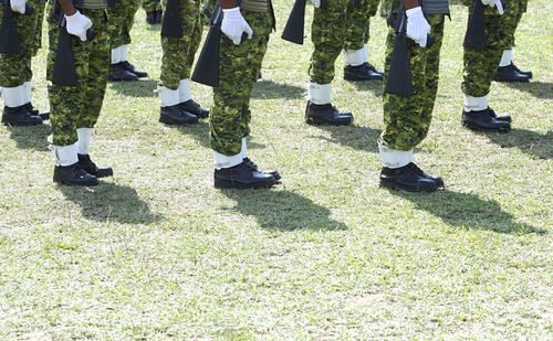 Low section of military soldiers standing in field