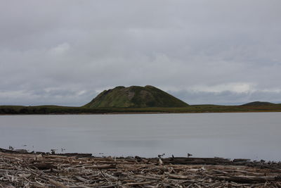 Scenic view of lake by mountain against sky