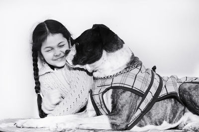 Smiling girl with boxer dog against wall