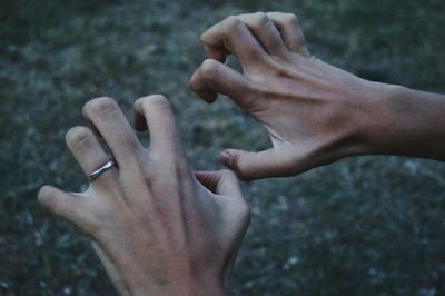 Close-up of cropped hands gesturing over field