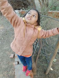 High angle view of girl standing on retaining wall