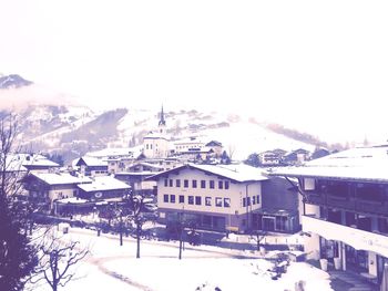 Houses in town against sky during winter