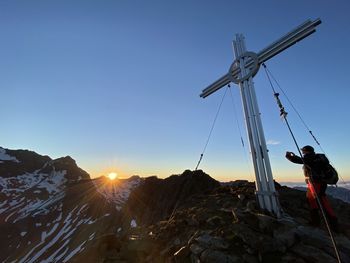 Man standing on mountain against clear blue sky