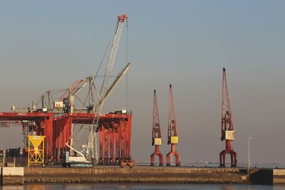 Cranes at construction site against clear sky