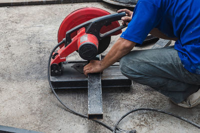 Worker man cutting steel with a circular steel cutter.