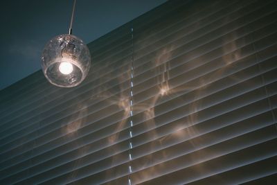 Low angle view of illuminated pendant light hanging from ceiling