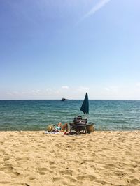 People at beach against clear sky