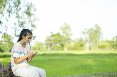 Young woman sitting on field
