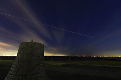 Low angle view of vapor trails in sky during dusk