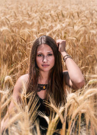 Portrait of beautiful woman sitting on field