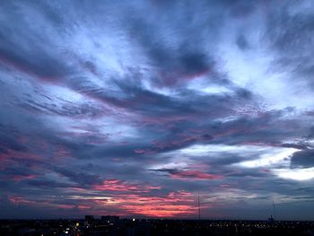 Scenic view of dramatic sky over city during sunset