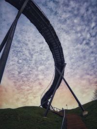 Low angle view of metallic structure on field against sky