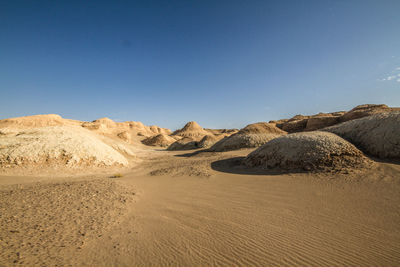 Scenic view of desert mountain forms like cake against clear blue sky