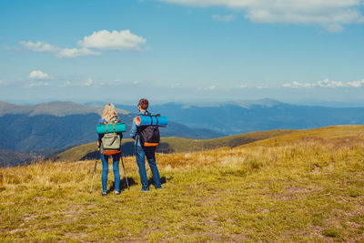 Couple on mountain against sky