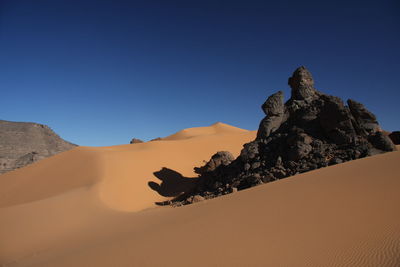 Rock formations in desert against clear sky acacus mountains, libya