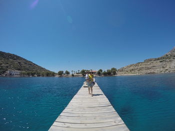 Scenic view of lake against clear blue sky