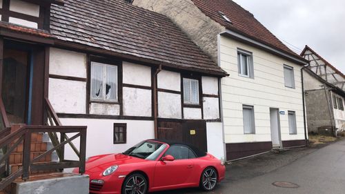 Car outside house against sky