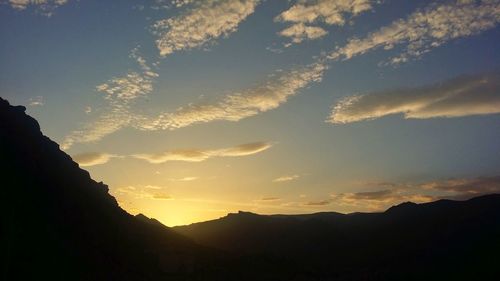 Scenic view of silhouette mountains against sky at sunset