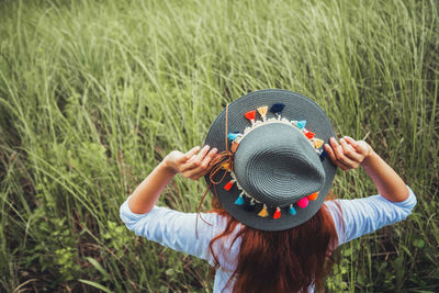 Rear view of woman wearing hat on field