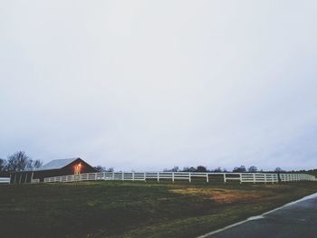 Road amidst field against clear sky