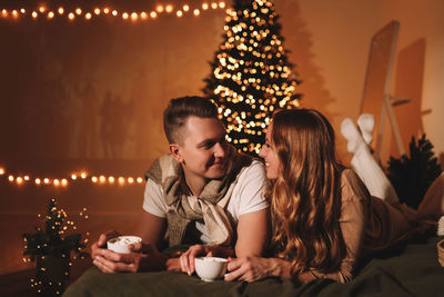 A romantic couple in love celebrates christmas holidays and new year in a cozy house at night