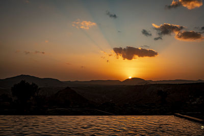 Scenic view of silhouette mountains against sky during sunset