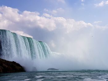 Scenic view of waterfall against sky