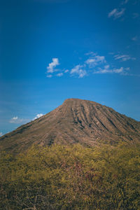 Scenic view of mountains against blue sky