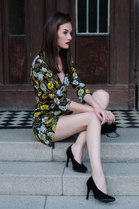 Beautiful young woman sitting outdoors