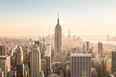 Aerial view of buildings in city against clear sky