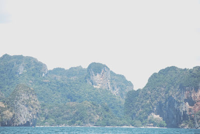 Scenic view of sea and mountains against clear sky