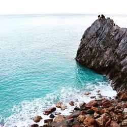 Rock formation on sea shore against sky