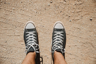 Low section of man standing on tiled floor