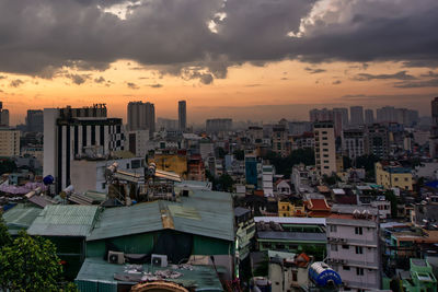 Aerial view of buildings in city against sky during sunset