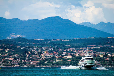 Scenic view of sea by townscape against sky