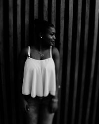 Woman standing against curtain at home