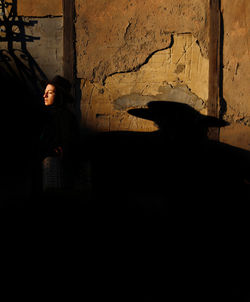 Shadow of woman standing against wall